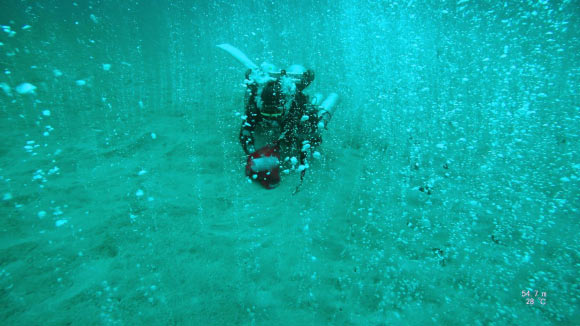 A researcher collects gas samples at Soda Springs in the Philippines. Image credit: Jackson School of Geosciences, University of Texas at Austin.