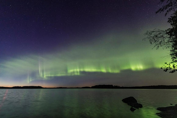 The auroral dunes appear as a green-tinged and even pattern of waves resembling a striped veil of clouds or dunes on a sandy beach. Image credit: Kari Saari.