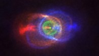 This ALMA image shows the outcome of a stellar fight: a complex and stunning gas environment surrounding the binary system HD 101584. The colors represent speed, going from blue (gas moving the fastest towards us) to red (gas moving the fastest away from us). Jets, almost along the line of sight, propel the material in blue and red. The stars in the binary are located at the single bright dot at the center of the ring-like structure shown in green, which is moving with the same velocity as the system as a whole along the line of sight. Astronomers believe this ring has its origin in the material ejected as the lower mass star in the binary spiraled towards its red-giant partner. Image credit: ALMA / ESO / NAOJ / NRAO / Olofsson et al / Robert Cumming.