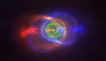 This ALMA image shows the outcome of a stellar fight: a complex and stunning gas environment surrounding the binary system HD 101584. The colors represent speed, going from blue (gas moving the fastest towards us) to red (gas moving the fastest away from us). Jets, almost along the line of sight, propel the material in blue and red. The stars in the binary are located at the single bright dot at the center of the ring-like structure shown in green, which is moving with the same velocity as the system as a whole along the line of sight. Astronomers believe this ring has its origin in the material ejected as the lower mass star in the binary spiraled towards its red-giant partner. Image credit: ALMA / ESO / NAOJ / NRAO / Olofsson et al / Robert Cumming.