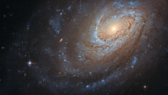 This Hubble image shows the spiral galaxy NGC 4651. The color image was made from separate exposures taken in the visible and near-infrared regions of the spectrum with Hubble’s Advanced Camera for Surveys (ACS) instrument. Two filters were used to sample various wavelengths. The color results from assigning different hues to each monochromatic image associated with an individual filter. Image credit: NASA / ESA / Hubble / D. Leonard.