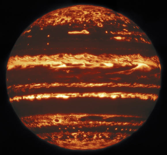This illustration of lightning, convective towers (thunderheads), deep water clouds, and clearings in Jupiter’s atmosphere is based on data collected by the Juno spacecraft, the Hubble Space Telescope, and the Gemini Observatory. Juno detects radio signals generated by lightning discharges. Because radio waves can pass through all of Jupiter’s cloud layers, Juno is able to detect lightning in deep clouds as well as lightning on the day side of the planet. Hubble detects sunlight that has reflected off clouds in Jupiter’s atmosphere. Different wavelengths penetrate to different depths in the clouds, giving researchers the ability to determine the relative heights of cloud tops. Gemini maps the thickness of cool clouds that block thermal infrared light from warmer atmospheric layers below the clouds. Thick clouds appear dark in the infrared maps, while clearings appear bright. The combination of observations can be used to map the cloud structure in three dimensions and infer details of atmospheric circulation. Thick, towering clouds form where moist air rises (upwelling and active convection). Clearings form where drier air sinks (downwelling). The clouds shown rise five times higher than similar convective towers in Earth’s relatively shallow atmosphere. The region illustrated covers a horizontal span one third greater than that of the continental United States. Image credit: NASA / ESA / M.H. Wong, University of California, Berkeley / A. James & M.W. Carruthers, STScI.