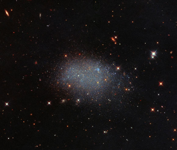 This Hubble image shows the isolated dwarf galaxy ESO 461-036. This image is made up of observations from Hubble’s Wide Field Camera 3 (WFC3) and Advanced Camera for Surveys (ACS) in the infrared and optical parts of the spectrum. Four filters were used to sample various wavelengths. The color results from assigning different hues to each monochromatic image associated with an individual filter. Image credit: NASA / ESA / Hubble / E. Shaya et al.