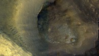 This image from NASA’s Mars Reconnaissance Orbiter (MRO) shows a hill with a central crater. Such features have been interpreted as both mud volcanoes (really a sedimentary structure) and as actual volcanoes (the erupting lava kind). They occur on the floor of Valles Marineris below a closed topographic contour that could have held a lake, and the compaction of wet sediments may have created mud volcanoes. Image credit: NASA / JPL-Caltech / University of Arizona.