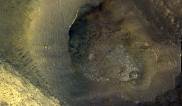 This image from NASA’s Mars Reconnaissance Orbiter (MRO) shows a hill with a central crater. Such features have been interpreted as both mud volcanoes (really a sedimentary structure) and as actual volcanoes (the erupting lava kind). They occur on the floor of Valles Marineris below a closed topographic contour that could have held a lake, and the compaction of wet sediments may have created mud volcanoes. Image credit: NASA / JPL-Caltech / University of Arizona.