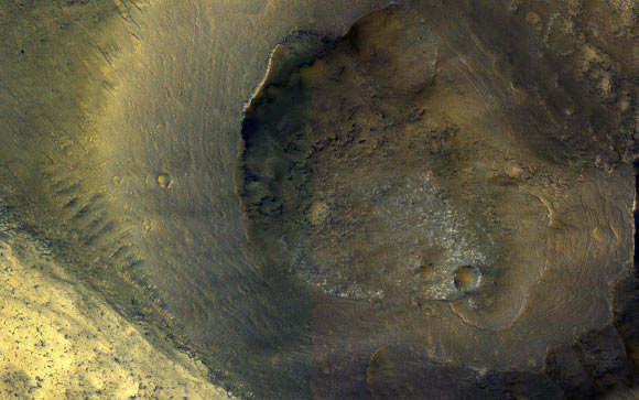 This image from NASA’s Mars Reconnaissance Orbiter (MRO) shows a hill with a central crater. Such features have been interpreted as both mud volcanoes (really a sedimentary structure) and as actual volcanoes (the erupting lava kind). They occur on the floor of Valles Marineris below a closed topographic contour that could have held a lake, and the compaction of wet sediments may have created mud volcanoes. Image credit: NASA / JPL-Caltech / University of Arizona.