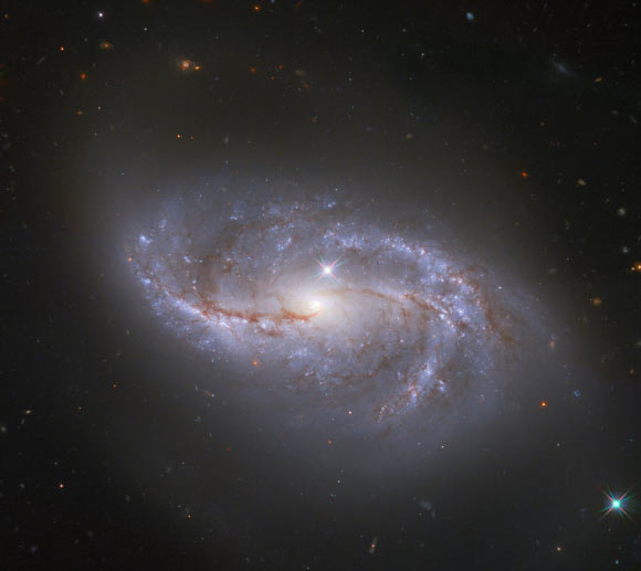 This Hubble image shows NGC 2608, a barred spiral galaxy located 64 million light-years away in the constellation Cancer. The picture was created from images taken with Hubble’s Wide Field Camera 3 (WFC3). It combines observations gathered in four different filters, bringing together visible and infrared light to show off this galaxy in all its glory. The color results from assigning different hues to each monochromatic image associated with an individual filter. Image credit: NASA / ESA / Hubble / A. Riess et al.