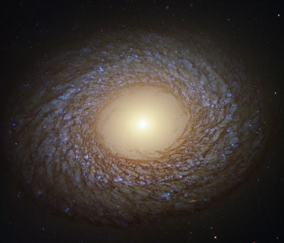 This Hubble image shows a flocculent spiral galaxy called NGC 2775. The image was made from separate exposures taken in the visible, ultraviolet and near-infrared regions of the spectrum with Hubble’s Wide Field Camera 3 (WFC3). It is based on data obtained through five filters. The color results from assigning different hues to each monochromatic image associated with an individual filter. Image credit: NASA / ESA / Hubble / J. Lee / PHANGS-HST Team / Judy Schmidt, www.geckzilla.com.