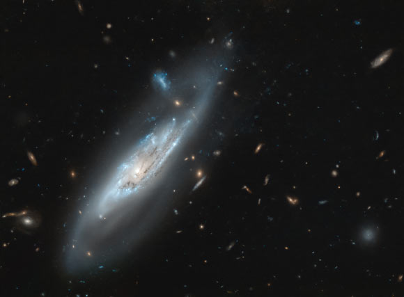 This Hubble image shows the barred spiral galaxy NGC 4848. The picture was snapped by Hubble’s Wide Field Camera 3 (WFC3). The image was made through two filters. The color results from assigning different hues to each monochromatic image associated with an individual filter. Image credit: NASA / ESA / Hubble / M. Gregg.