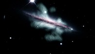 This composite image shows the edge-on spiral galaxy NGC 4217. Magnetic field lines (green), revealed by the VLA, extend far above and below the plane of the galaxy. Image credit: Y. Stein, Centre de Données astronomiques de Strasbourg / NRAO / SDSS / KPNO / J. English, University of Manitoba / R.-J. Dettmar & A. Miskolczi, Ruhr-Universität Bochum / R.J. Rand, U.N.M. / J. Irwin, Queen’s University.