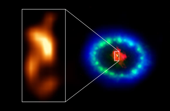 Extremely high-resolution ALMA images revealed a hot blob in the dusty core of SN 1987A (inset), which could be the location of the missing neutron star. The red color shows dust and cold gas in the center of the supernova remnant, taken at radio wavelengths with ALMA. The green and blue hues reveal where the expanding shock wave from the exploded star is colliding with a ring of material around the supernova. The green represents the glow of visible light, captured by the NASA/ESA Hubble Space Telescope. The blue color reveals the hottest gas and is based on data from NASA’s Chandra X-ray Observatory. The ring was initially made to glow by the flash of light from the original explosion. Over subsequent years the ring material has brightened considerably as the explosion’s shock wave slams into it. Image credit: ALMA / ESO / NAOJ / NRAO / P. Cigan / R. Indebetouw / AUI / NSF / B. Saxton / NASA / ESA / Hubble / Chandra.