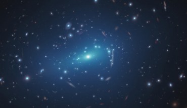 This Hubble image shows the massive galaxy cluster MACSJ 1206. Embedded within the cluster are the distorted images of distant background galaxies, seen as arcs and smeared features. These distortions are caused by the dark matter in the cluster, whose gravity bends and magnifies the light from faraway galaxies, an effect called gravitational lensing. This phenomenon allows astronomers to study remote galaxies that would otherwise be too faint to see. Overlaid on the image are small-scale concentrations of dark matter, represented in this artist’s impression in blue. Dark matter is the invisible glue that keeps stars bound together inside a galaxy and makes up the bulk of the matter in the Universe. These blue halos reflect how the galaxy cluster’s dark matter is distributed, revealed by new results from Hubble. Image credit: NASA / ESA / Hubble / G. Caminha, University of Groningen / M. Meneghetti, Observatory of Astrophysics and Space Science of Bologna / P. Natarajan, Yale University / CLASH Team / M. Kornmesser.
