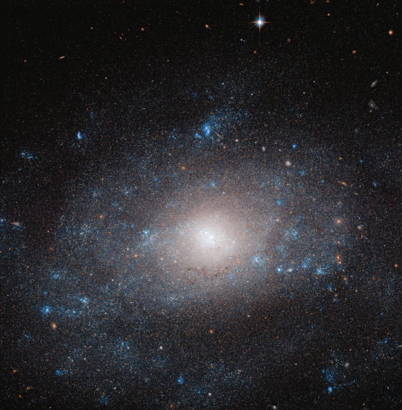 This Hubble image shows the spiral galaxy NGC 5585. Hotspots of star formation can be seen along the galaxy’s faint spiral arms. These regions shine a brilliant blue, contrasting strikingly against the ever-black background of space. The color image is made up of observations from Hubble’s Advanced Camera for Surveys (ACS) in the near-infrared and optical parts of the spectrum. Two filters were used to sample various wavelengths. The color results from assigning different hues to each monochromatic image associated with an individual filter. Image credit: NASA / ESA / Hubble / R. Tully / Gagandeep Anand.