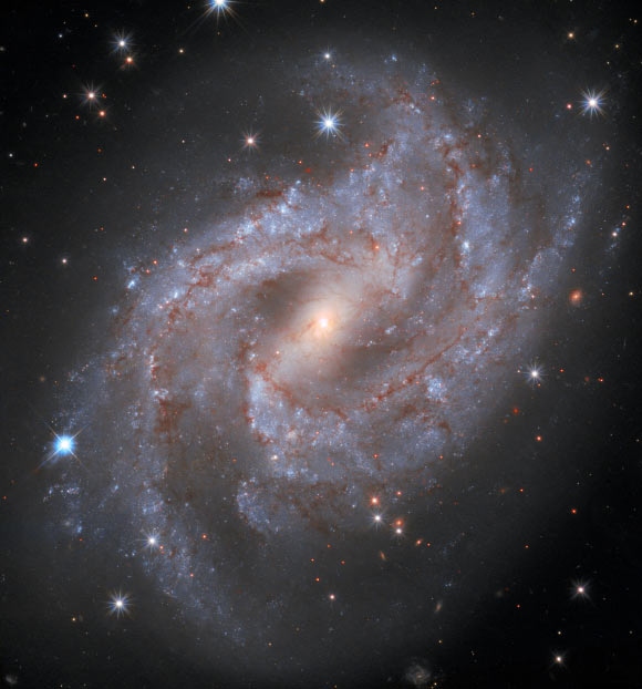 This Hubble images shows SN 2018gv (a very bright star located on the outer edge of one of the galaxy’s spiral arms in the left portion of the image) in the barred spiral galaxy NGC 2525. Image credit: NASA / ESA / Hubble / A. Riess & SH0ES Team / Mahdi Zamani.