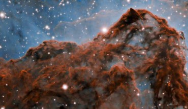 A 5-light-year-long section of the western wall in the Carina Nebula, as observed with adaptive optics on the Gemini South telescope. This mountainous section of the nebula reveals a number of unusual structures including a long series of parallel ridges that could be produced by a magnetic field, a remarkable almost perfectly smooth wave, and fragments that appear to be in the process of being sheared off the cloud by a strong wind. There is also evidence for a jet of material ejected from a newly-formed star. The exquisite detail seen in the image is in part due to a technology known as adaptive optics, which resulted in a ten-fold improvement in the resolution of the research team’s observations. Image credit: International Gemini Observatory / NOIRLab / NSF / AURA / Patrick Hartigan, Rice University / Travis Rector, University of Alaska Anchorage / Mahdi Zamani / Davide de Martin.
