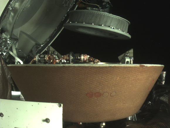 This image shows OSIRIS-REx’s collector head hovering over the Sample Return Capsule after the Touch-And-Go Sample Acquisition Mechanism arm moved it into the proper position for capture. Image credit: NASA’s Goddard Space Flight Center / University of Arizona / Lockheed Martin.