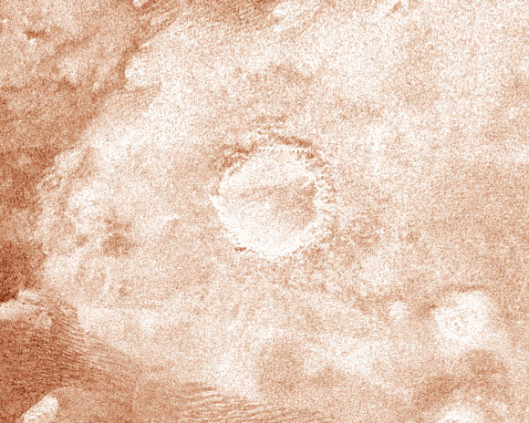 This colorized radar image, taken by NASA’s Cassini orbiter on February 15, 2005, shows a 60-km (37-mile) wide crater on Titan. The appearance of the crater and the extremely bright (hence rough) blanket of material surrounding it is indicative of an origin by impact, in which a hypervelocity comet or asteroid, in this case, roughly 5-10 km (3-6 miles) in size, slammed into the surface of the moon. The bright surrounding blanket is debris, or ejecta, thrown out of the crater. The asymmetric appearance of this ejecta blanket could be an effect of atmospheric winds associated with the impact itself. Although clearly formed by impact, the feature lacks a central peak, suggesting that it has been eroded or otherwise modified after formation. Rainfall, wind erosion, and softening of the solid material in which the crater formed are all possible processes that might have altered this impact feature. Image credit: NASA / JPL-Caltech / ASI.