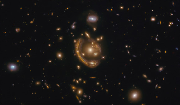 This Hubble image shows GAL-CLUS-022058-38303, the largest, nearly-complete Einstein ring known. The image is made up of observations from Hubble’s Wide Field Camera 3 (WFC3) in the infrared and optical parts of the spectrum. Three filters were used to sample various wavelengths. The color results from assigning different hues to each monochromatic image associated with an individual filter. Image credit: NASA / ESA / Hubble / Saurabh Jha, Rutgers the State University of New Jersey / L. Shatz.