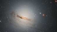 This Hubble image shows NGC 1947, a lenticular galaxy located some 40 million light-years away in the constellation Dorado. The color image of NGC 1947 was made from separate exposures taken in the visible and infrared regions of the spectrum with Hubble’s Wide Field Camera 3 (WFC3). Two filters were used to sample various wavelengths. The color results from assigning different hues to each monochromatic image associated with an individual filter. Image credit: NASA / ESA / Hubble / D. Rosario / L. Shatz.