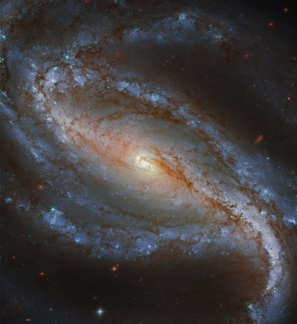 This image of the barred spiral galaxy NGC 613 was snapped by Hubble’s Advanced Camera for Surveys (ACS). The color composite was assembled from images taken in visible and near-infrared light. Three filters were used to sample various wavelengths. The color results from assigning different hues to each monochromatic image associated with an individual filter. Image credit: NASA / ESA / Hubble / G. Folatelli.