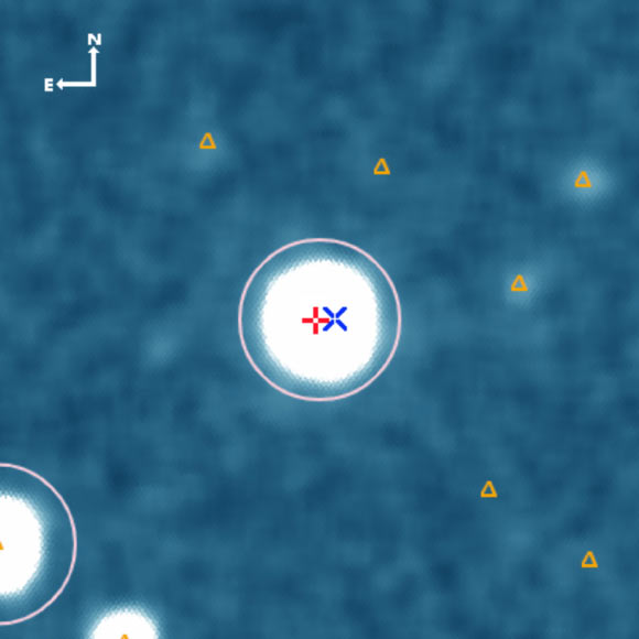 NGTS deep stacked image centered on NGTS-14A. The Gaia positions of NGTS-14A and NGTS-14B are indicated with a red ‘+’ and a blue ‘x,’ respectively. The pink circle indicates the NGTS photometric aperture. Other Gaia sources are marked with orange triangles. North is up, and East to the left. Image credit: Smith et al., arXiv: 2101.01470.