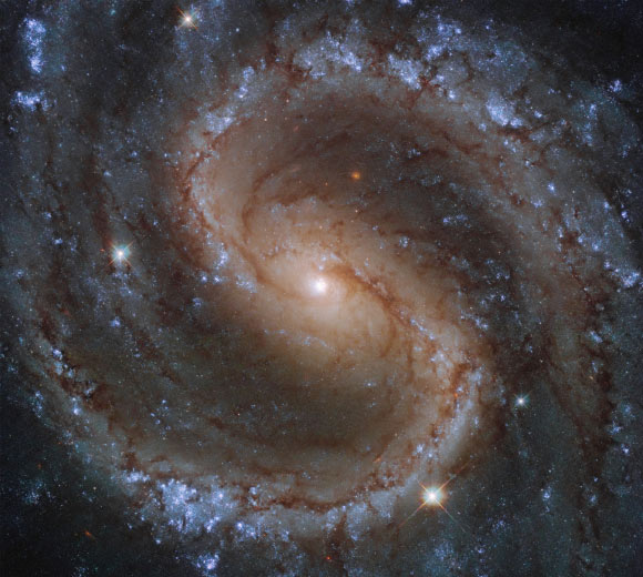 This Hubble image shows the barred spiral galaxy NGC 4535. The color image is made up of observations from Hubble’s Wide Field Camera 3 (WFC3) in the ultraviolet, near-infrared, and optical parts of the spectrum. Five filters were used to sample various wavelengths. The color results from assigning different hues to each monochromatic image associated with an individual filter. Image credit: NASA / ESA / Hubble / J. Lee / PHANGS-HST Team.