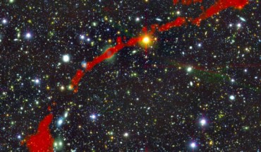 This image shows the giant radio galaxy MGTC J095959.63+024608.6; in the background is the sky as seen in optical light; overlaid in red is the radio light from the giant radio galaxy, as seen by MeerKAT. Image credit: I. Heywood, University of Oxford / Rhodes University / South African Radio Astronomy Observatory / CC BY 4.0.
