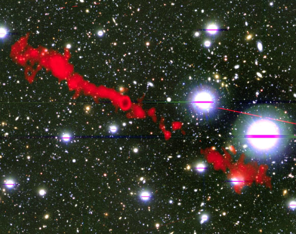 This image shows the giant radio galaxy MGTC J100016.84+015133.0; in the background is the sky as seen in optical light; overlaid in red is the radio light from the giant radio galaxy, as seen by MeerKAT. Image credit: I. Heywood, University of Oxford / Rhodes University / South African Radio Astronomy Observatory / CC BY 4.0.