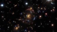 An example of a gravitational lens found in the DESI Legacy Surveys data. There are four sets of lensed images in DESI-090.9854-35.9683, corresponding to four distinct background galaxies -- from the outermost giant red arc to the innermost bright blue arc, arranged in four concentric circles. All of them are gravitationally lensed by the orange galaxy at the very center. Image credit: NOIRLab.