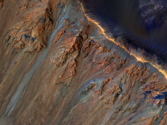HiRISE camera view of Krupac crater on Mars featuring gullies along the rim and recurring slope lineae lower down the crater wall. Image credit: NASA / JPL / University of Arizona.