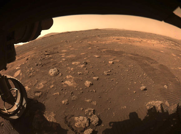 This image was captured while Perseverance drove on Mars for the first time on March 4, 2021. One of Perseverance’s Hazard Avoidance Cameras (Hazcams) captured this image as the rover completed a short traverse and turn from its landing site in Jezero Crater. Image credit: NASA / JPL-Caltech.