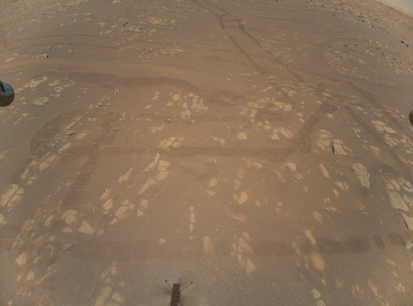 This is the first color image of the Martian surface taken by an aerial vehicle while it was aloft. The Ingenuity helicopter captured it with its color camera during its second successful flight test on April 22, 2021. At the time this image, Ingenuity was 5.2 m (17 feet) above the surface and pitching (moving the camera’s field of view upward) so the helicopter could begin its 2-m (7-foot) translation to the west -- away from the rover. The image, as well as the inset showing a close-up of a portion of the tracks the Perseverance rover and the surface features, demonstrates the utility of scouting Martian terrain from an aerial perspective. Image credit: NASA / JPL-Caltech.