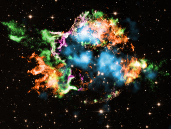 This composite image, taken by NASA’s Chandra X-ray Observatory and the NASA/ESA Hubble Space Telescope, shows the supernova remnant Cassiopeia A; the different colors represent elements detected by Chandra: iron (orange), oxygen (purple), and the amount of silicon compared to magnesium (green); titanium (light blue) detected previously by NASA’s NuSTAR telescope is shown, but not the different type of titanium found by Chandra. Image credit: NASA / CXC / RIKEN / Sato et al. / NuSTAR.