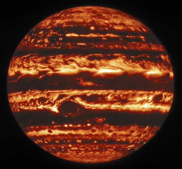 This infrared view of Jupiter was created from data captured on January 11, 2017 with the Near-InfraRed Imager on the Gemini North telescope. In the image warmer areas appear bright, including four large hot spots that appear in a row just north of the equator. South of the equator, the oval-shaped and cloud-covered Great Red Spot appears dark. Image credit: Gemini Observatory / NOIRLab / NSF / AURA / Wong et al. / de Pater et al. / M. Zamani.