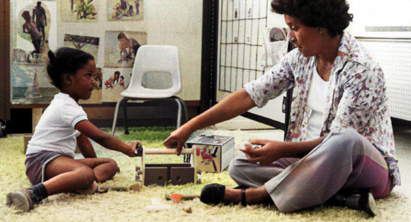 A teacher guides a student through a task in this historical photo of the Abecedarian Project. Image credit: Virginia Tech.