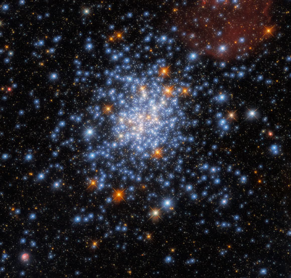 This Hubble image shows the open star cluster NGC 330. The color image was made from separate exposures taken in the ultraviolet, visible and near-infrared regions of the spectrum with Hubble’s Wide Field Camera 3 (WFC3). Four filters were used to sample various wavelengths. The color results from assigning different hues to each monochromatic image associated with an individual filter. Image credit: NASA / ESA / Hubble / J. Kalirai / A. Milone.