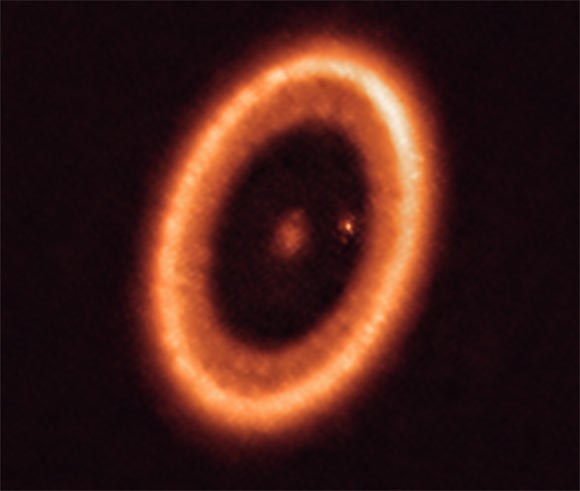 This ALMA image shows the PDS 70 planetary system. The system features a star at its center and at least two planets orbiting it, PDS 70b (not visible in the image) and PDS 70c, surrounded by a circumplanetary disk (the dot to the right of the star). Image credit: ALMA / ESO / NAOJ / NRAO / Benisty et al.