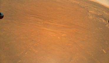 This image shows the South Séítah region of Jezero Crater, captured by NASA’s Ingenuity helicopter during its 11th flight on August 4, 2021. At the bottom center of the image is Ingenuity’s shadow. Above it, toward the top of the frame -- just beyond the dune field and right of center -- is the Perseverance rover (white circle). Image credit: NASA / JPL-Caltech.