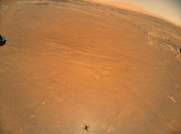 This image shows the South Séítah region of Jezero Crater, captured by NASA’s Ingenuity helicopter during its 11th flight on August 4, 2021. At the bottom center of the image is Ingenuity’s shadow. Above it, toward the top of the frame -- just beyond the dune field and right of center -- is the Perseverance rover (white circle). Image credit: NASA / JPL-Caltech.