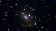 This composite image of the galaxy cluster MACSJ 0138 shows data from ALMA and Hubble. Image credit: ALMA / ESO / NAOJ / NRAO / S. Dagnello, NRAO / STScI / Whitaker et al.