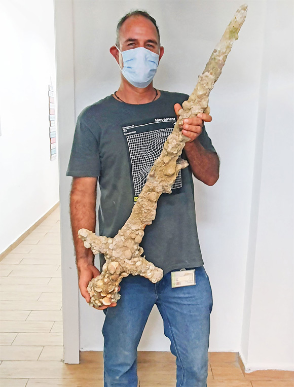 Shlomi Katzin with the 900-year-old crusader sword. Image credit: Nir Distelfeld / Israel Antiquities Authority.