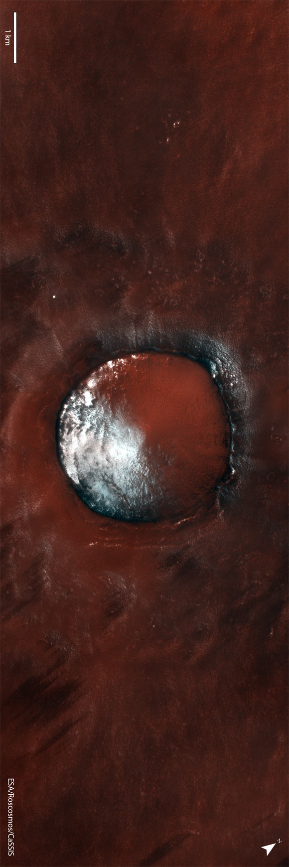 The new TGO image shows a small crater partly filled with water ice in Vastitas Borealis on Mars. Image credit: ESA / Roscosmos / CaSSIS / CC BY-SA 3.0 IGO.