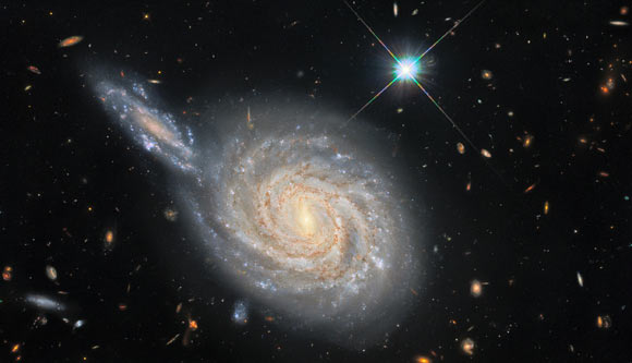 This image, taken with the NASA/ESA Hubble Space Telescope, depicts NGC 105, a spiral galaxy 215.5 million light-years away in the constellation of Pisces, and a smaller distant galaxy. Image credit: NASA / ESA / Hubble / D. Jones / Riess et al. / R. Colombari.