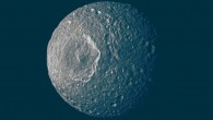 Mimas’ surface, like the surfaces of most of the other major Saturnian moons without atmospheres, is not pure ice but contains some dark impurities; the relatively dark markings appear along the lower portion of the walls of the 130-km-wide Herschel Crater (the peak in the middle of the crater is about as tall as Mount Everest; the impact that made it likely almost destroyed the moon) and some of the smaller craters; scientists interpret this darkening as evidence for the gradual concentration of impurities from evaporating icy materials in areas where the dark impurities slide slowly down the crater wall. Image credit: NASA / JPL / Space Science Institute.