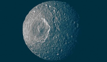 Mimas’ surface, like the surfaces of most of the other major Saturnian moons without atmospheres, is not pure ice but contains some dark impurities; the relatively dark markings appear along the lower portion of the walls of the 130-km-wide Herschel Crater (the peak in the middle of the crater is about as tall as Mount Everest; the impact that made it likely almost destroyed the moon) and some of the smaller craters; scientists interpret this darkening as evidence for the gradual concentration of impurities from evaporating icy materials in areas where the dark impurities slide slowly down the crater wall. Image credit: NASA / JPL / Space Science Institute.