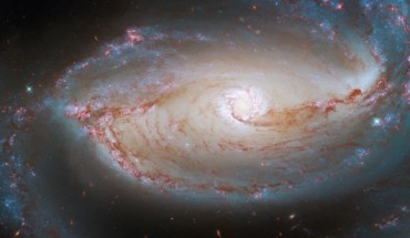 This Hubble image shows NGC 1097, a barred spiral galaxy some 48 million light-years away in the constellation of Fornax. The color image is made up of observations from Hubble’s Wide Field Camera 3 and Advanced Camera for Surveys in the ultraviolet, near-infrared, and optical parts of the spectrum. Seven filters were used to sample various wavelengths. The color results from assigning different hues to each monochromatic image associated with an individual filter. Image credit: NASA / ESA / Hubble / D. Sand / K. Sheth.