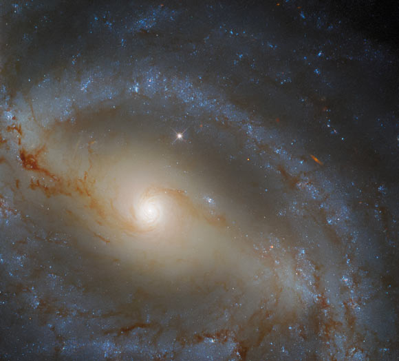This image shows NGC 5921, a barred spiral galaxy some 78 million light-years away in the constellation of Serpens. This picture was created from images taken with Hubble’s Wide Field Camera 3 (WFC3). One optical and two infrared filter were used to sample various wavelengths. The color results from assigning different hues to each monochromatic image associated with an individual filter. Image credit: NASA / ESA / Hubble / J. Walsh / R. Colombari.