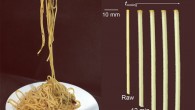 Hwang et al. studied the capillary-induced coalescence of swelling pasta; they observed that, as pasta is cooked (hence, swollen and softened), capillary action more easily deforms the noodle, and two pasta noodles can coalesce with the shorter stick length: (a) picture of spaghetti aglio e olio; capillary adhesion between the noodles is induced by olive oil seasoned with garlic and pepper; (b) pasta radial and axial growth over time at 100 degrees Celsius cooking due to hygroscopic swelling; radial strain grows up to 70% of its original and axial strain up to 40% of its original after 30 min of cooking (at 100 degrees Celsius); pasta cross section shows color-gradient before it is sufficiently cooked. Image credit: Hwang et al., doi: 10.1063/5.0083696.