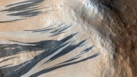 These dark slope streaks resulted from dust avalanches in Acheron Fossae, Mars. The HiRISE camera aboard NASA’s Mars Reconnaissance Orbiter captured them on December 3, 2006. Image credit: NASA / JPL-Caltech / University of Arizona.