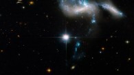 This Hubble image shows Hickson Compact Group 31, a group of four galaxies located some 166 million light-years away in the constellation of Eridanus. The bright, distorted object is actually two colliding dwarf galaxies. The bluish star clusters have formed in the streamers of debris pulled from the galaxies and at the site of their head-on collision. The cigar-shaped object to the right is another member of the group. A bridge of star clusters connects the trio. A longer rope of bright star clusters points to the fourth member of the group. The bright object in the center is a foreground star. Image credit: NASA / ESA / J. Charlton, Pennsylvania State University / G. Kober, NASA’s Goddard Space Flight Center / Catholic University of America.